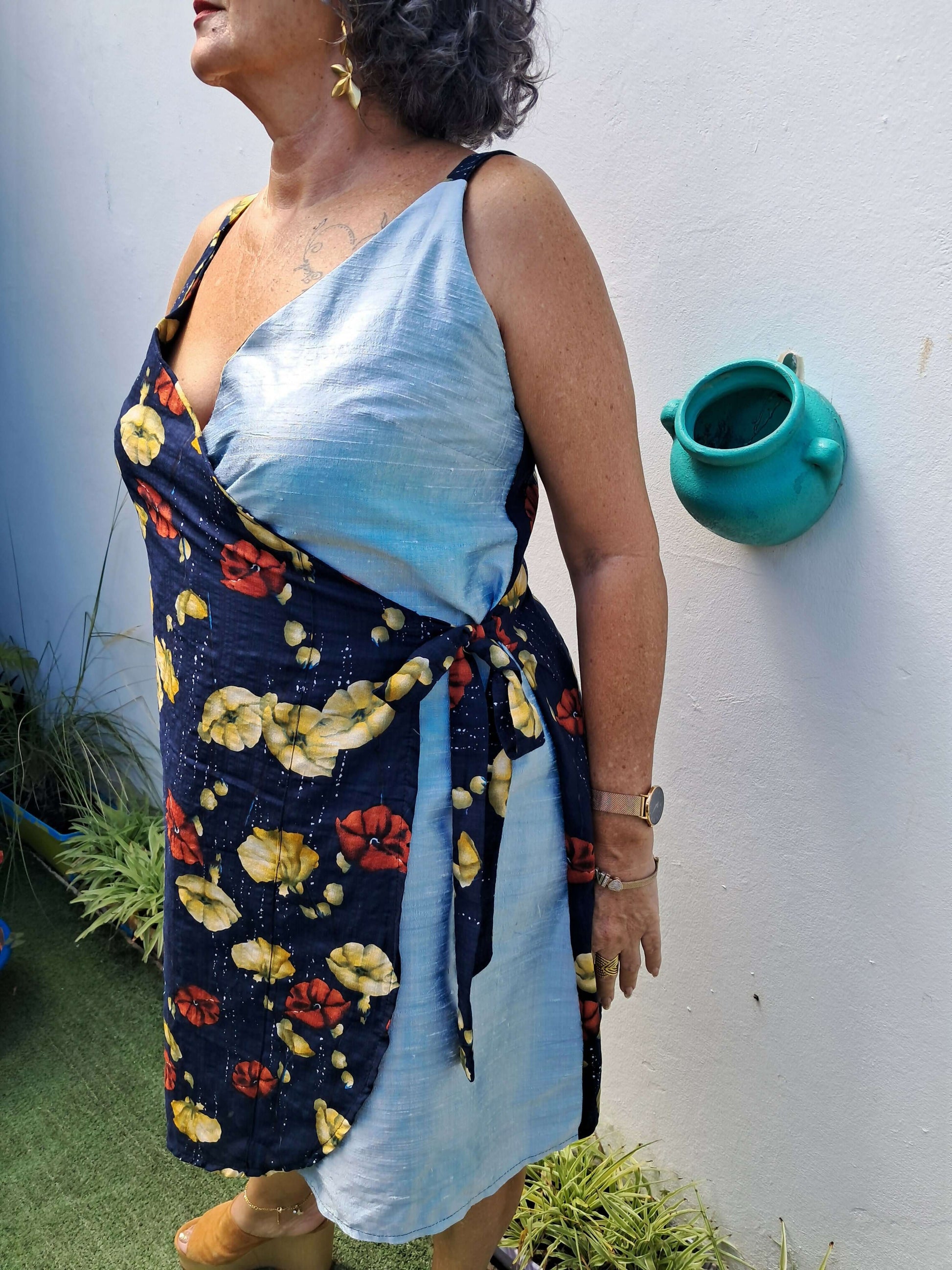 Femme portant une robe courte portefeuille à fleurs, style féminin, parfaite pour les couturières débutantes.