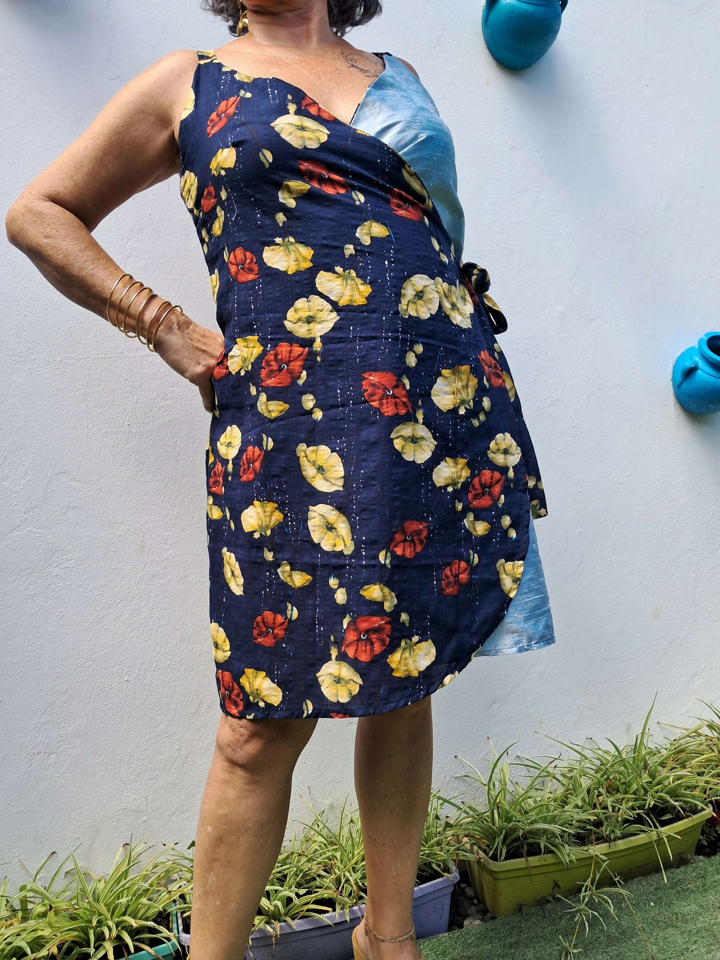 Femme portant une robe portefeuille Ostara aux fleurs, style débutant, à télécharger en PDF.