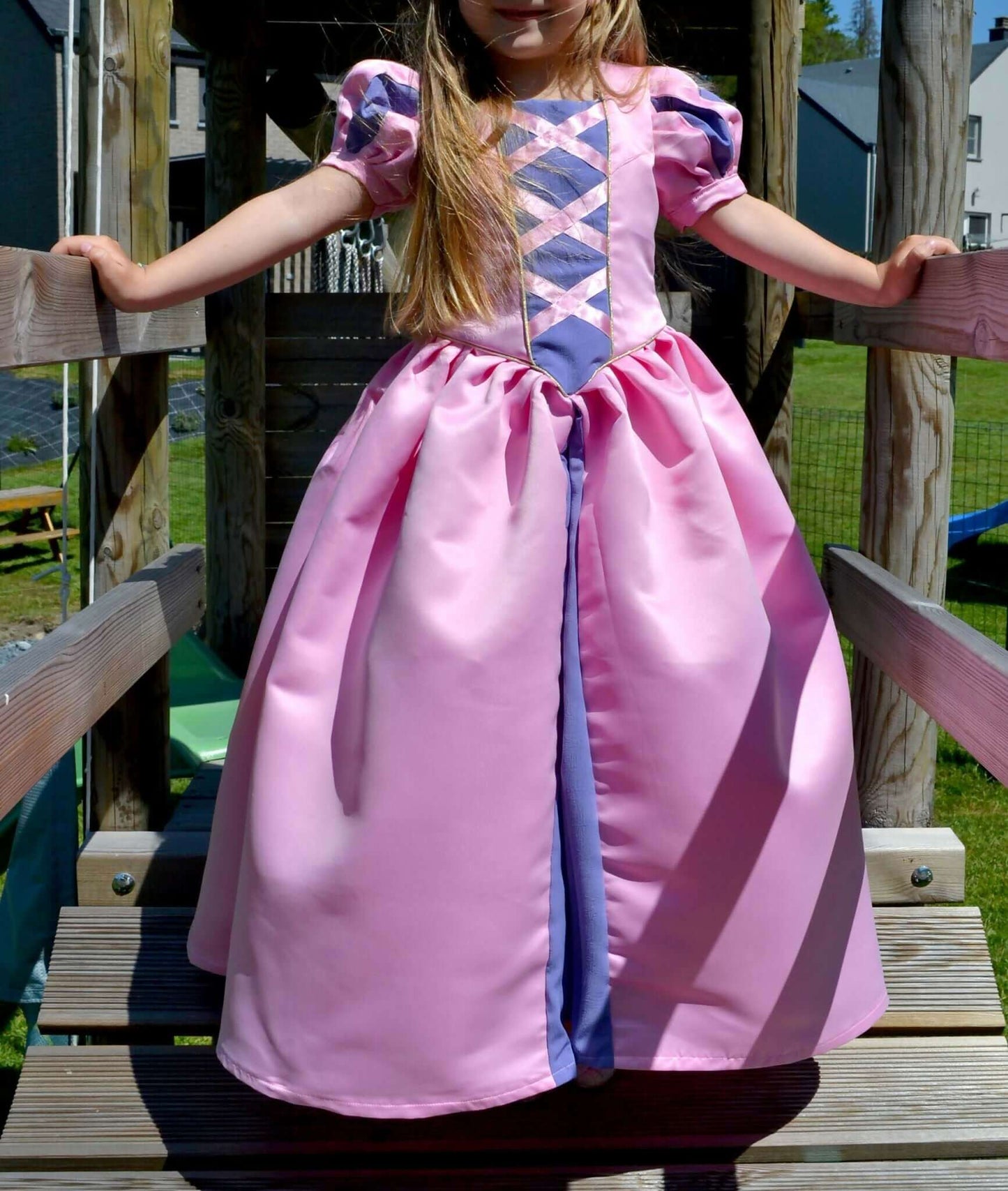 Fille portant la Robe Princesse Margaux Enfants rose vif avec manches ballon, idéale pour couture avec patron de couture pdf à télécharger.