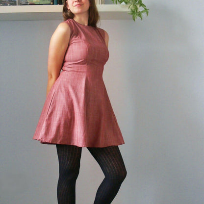 Femme portant la Robe Rochelle - 32 au 56 avec passepoil, patron de couture pdf à télécharger, style rétro et poches sur les côtés.