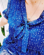 Détail d'une robe babydoll bleue avec col Lavallière et motifs à pois, idéale pour le patron de couture T36 à 50.