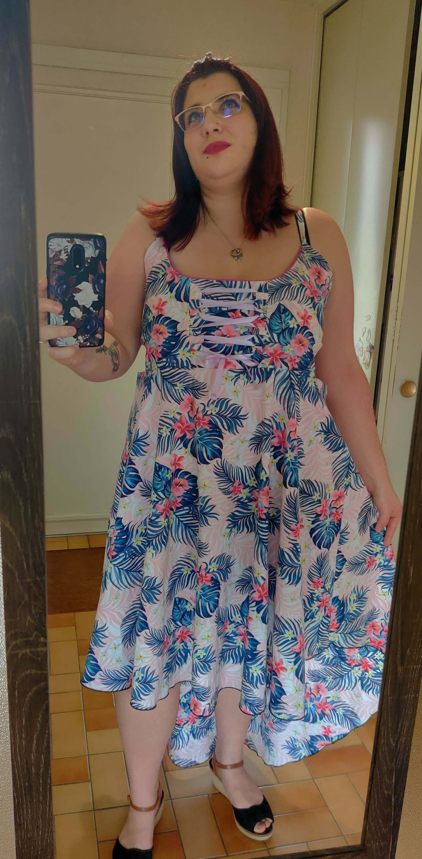 Femme portant une Robe Thoé - T36 à 50, coupe asymétrique, modèle floral, patron de couture pdf à télécharger disponible.