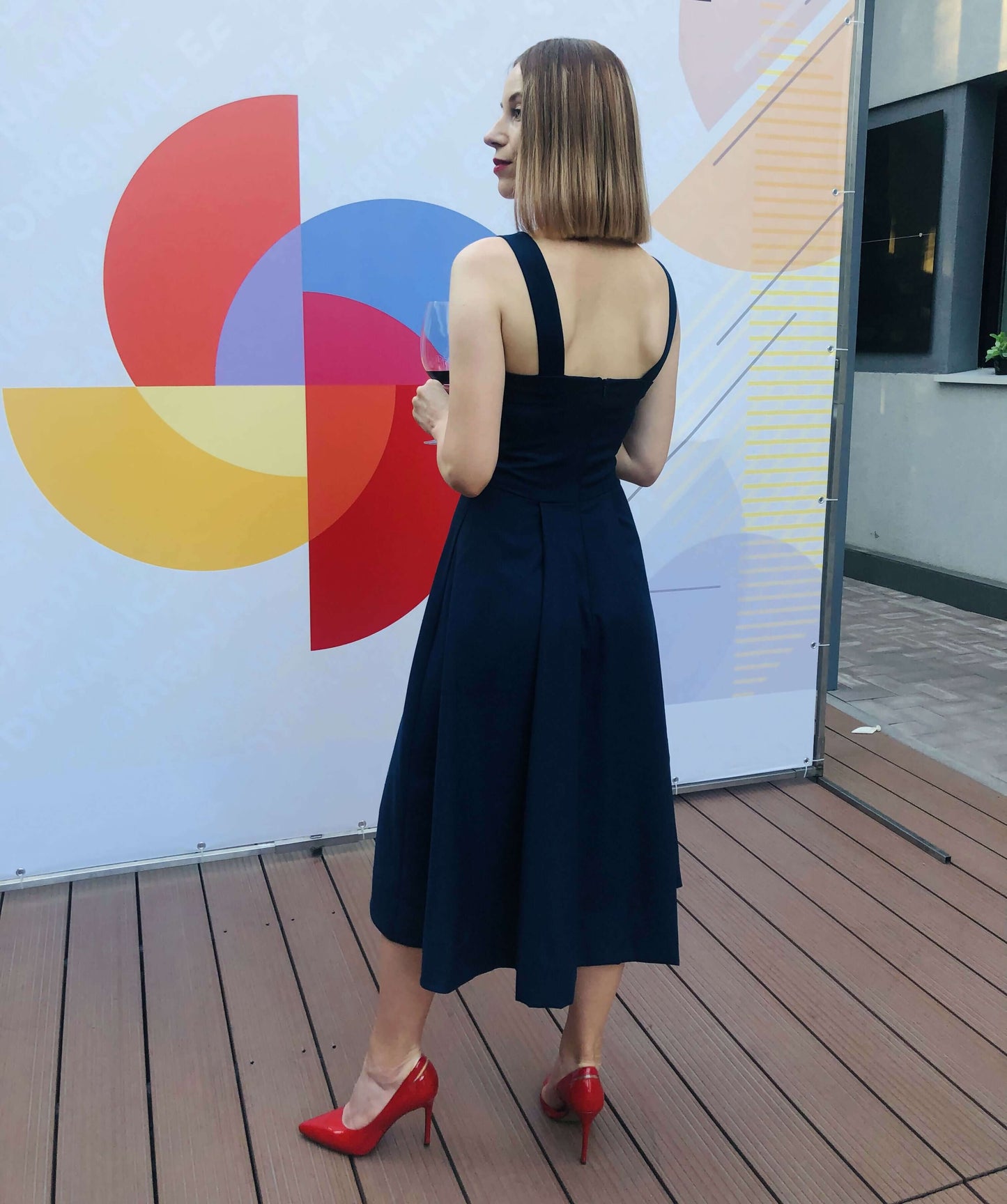 Robe - XS\XL - CLÉ du SUCCÈS, patron de couture PDF à télécharger, tenue élégante portée par une femme devant un fond coloré.