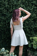 Femme portant une robe blanche, Robe - XS/XL - VANILLA, dans un jardin verdoyant. Patron de couture pdf à télécharger pour experts.