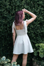 Femme portant une robe blanche, Robe - XS/XL - VANILLA, dans un jardin verdoyant. Patron de couture pdf à télécharger pour experts.