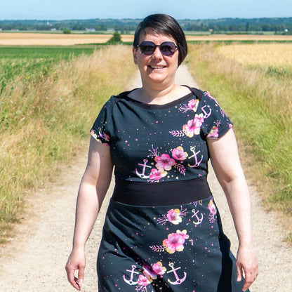 Femme portant Robe crop top jersey, 34 au 56, 4 statures - Ciboulette avec motif fleurs et ancres, sur un chemin champêtre.