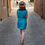 Femme en robe bleue Palmyre dans une rue pavée, patron de couture pdf à télécharger, Robe et top Palmyre - 32 au 56.