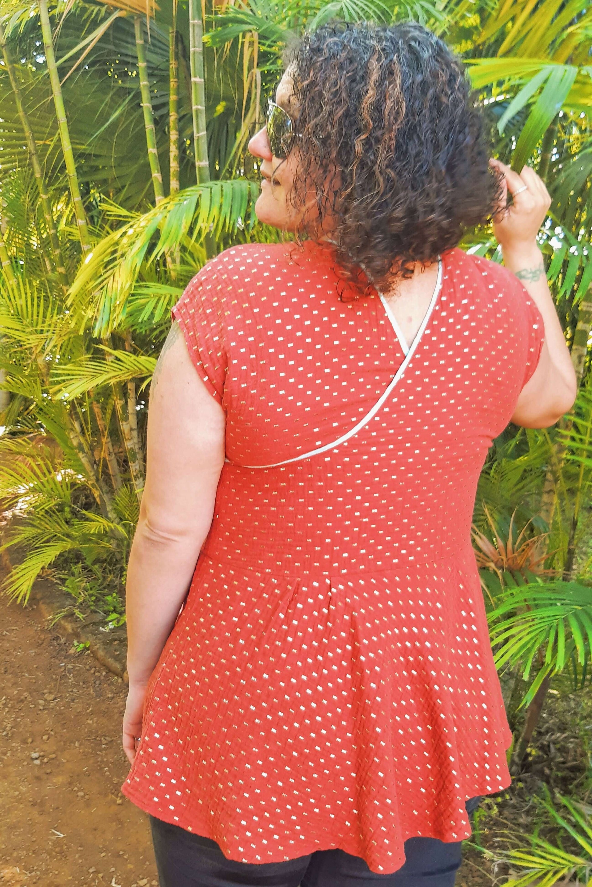 Femme portant le haut "Robe/Blouse Callisto - T36 à 50" dans un jardin, idéal pour l'été, patron de couture pdf à télécharger.