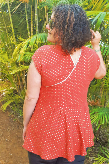 Femme portant le haut "Robe/Blouse Callisto - T36 à 50" dans un jardin, idéal pour l'été, patron de couture pdf à télécharger.