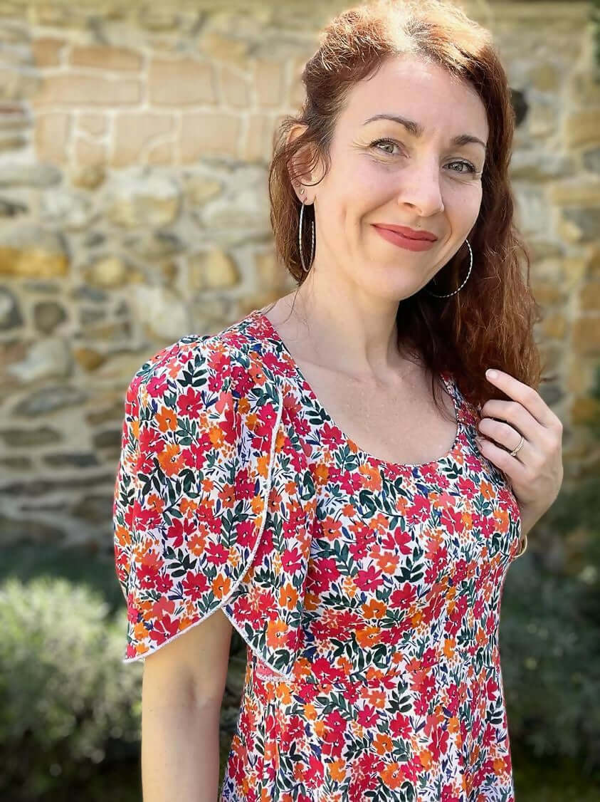 Femme portant la robe/top "Limurine" du 32 au 60, patron de couture pdf à télécharger, avec motif floral coloré.