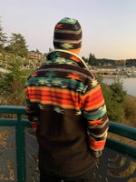 Homme portant SHERPA - La polaire mixte du XS au XXXL sur un pont, avec motif coloré, idéal pour l'hiver. Patron de couture pdf à télécharger.