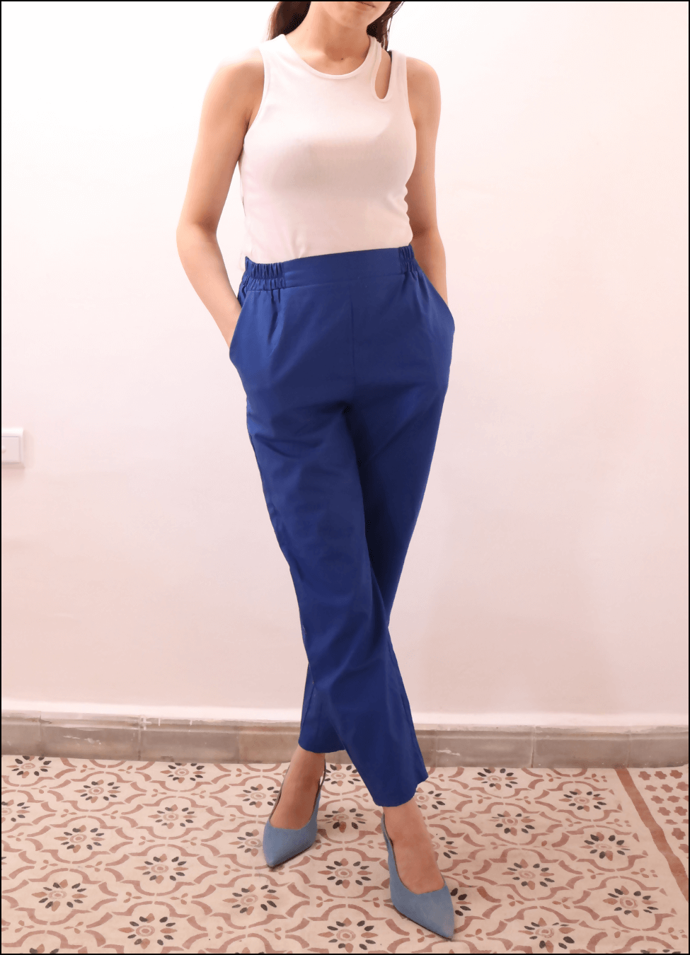 Modèle portant le SURI PANTALON-taille de 30 à 58 EU, pantalon bleu à pli, ceinture élastiquée, avec patron de couture pdf à télécharger.