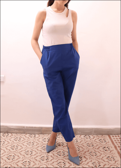 Modèle portant le SURI PANTALON-taille de 30 à 58 EU, pantalon bleu à pli, ceinture élastiquée, avec patron de couture pdf à télécharger.