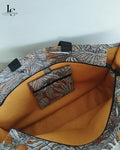 Sac cabas Margaret porté, détail des anses en tissu à motifs géométriques et intérieur en coton ocre