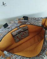 Sac cabas Margaret porté, détail des anses en tissu à motifs géométriques et intérieur en coton ocre