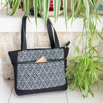 Sac cabas et sac à main, 4 tailles – Cumin avec motif géométrique, patron de couture pdf à télécharger, posé près de plantes vertes.