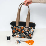 Sac cabas zippé, 3 formats – Fraise avec motifs floraux, patron de couture pdf à télécharger, sur une table avec accessoires de couture.