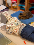 Enfant portant le Sweat AVENTURIER - Patron de couture PDF Enfant du 2 au 16 ans, allongé près d'un chat, sur un lit.