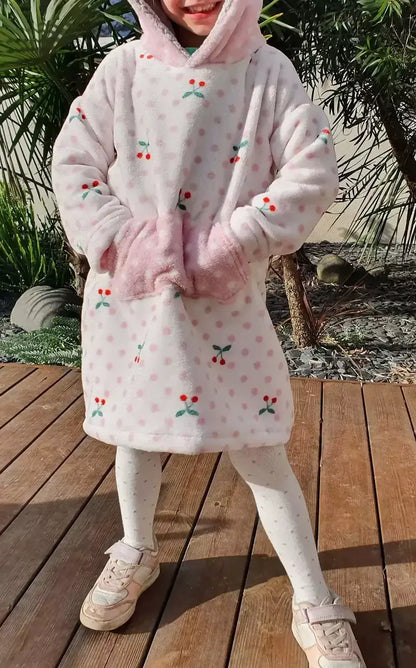 Enfant portant un Sweat Doudou Casimir Enfants rose avec motifs de cerises, parfait pour l'hiver. Patron de couture PDF à télécharger.