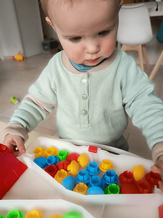 Enfant portant le Sweat MINI A - Patron PDF couture bébé du 12 mois au 4 ans, jouant avec des jouets colorés.
