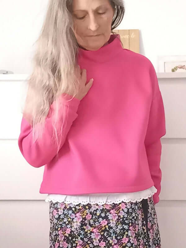 Femme portant un Sweat S pour Elle rose, patron de couture pdf à télécharger, avec col haut et jupe fleurie.