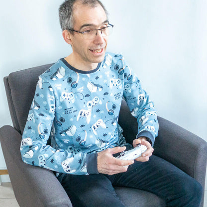 Homme portant un sweat imprimé original assis sur une chaise, idéal pour le patron de couture pdf à télécharger : Sweat mixte basique, XS au 3XL, 2 statures - Grenade.