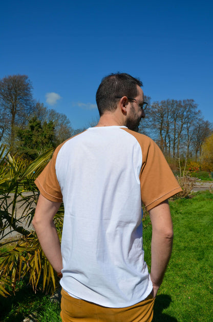 Homme portant un T-shirt à manches raglan beige et blanc, idéal pour créer des styles personnalisés en couture.