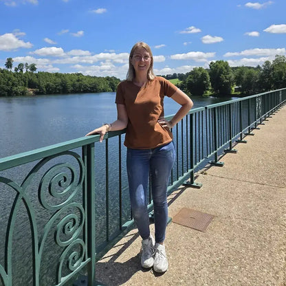 Femme portant le T-shirt Tao Femmes au bord d'un ruisseau, dans un cadre ensoleillé, avec le patron de couture pdf à télécharger.