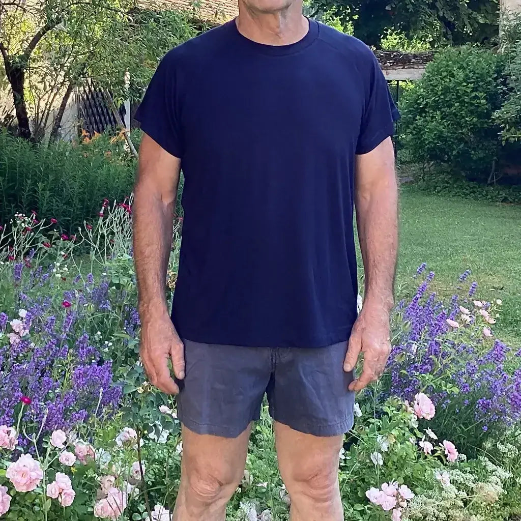 T-shirt Tao Hommes porté par un homme, devant un jardin fleuri, patron de couture pdf à télécharger.