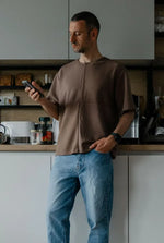 Homme portant un T-shirt homme du XXS au XXL - DOMINO, patron de couture pdf à télécharger, dans une cuisine moderne.