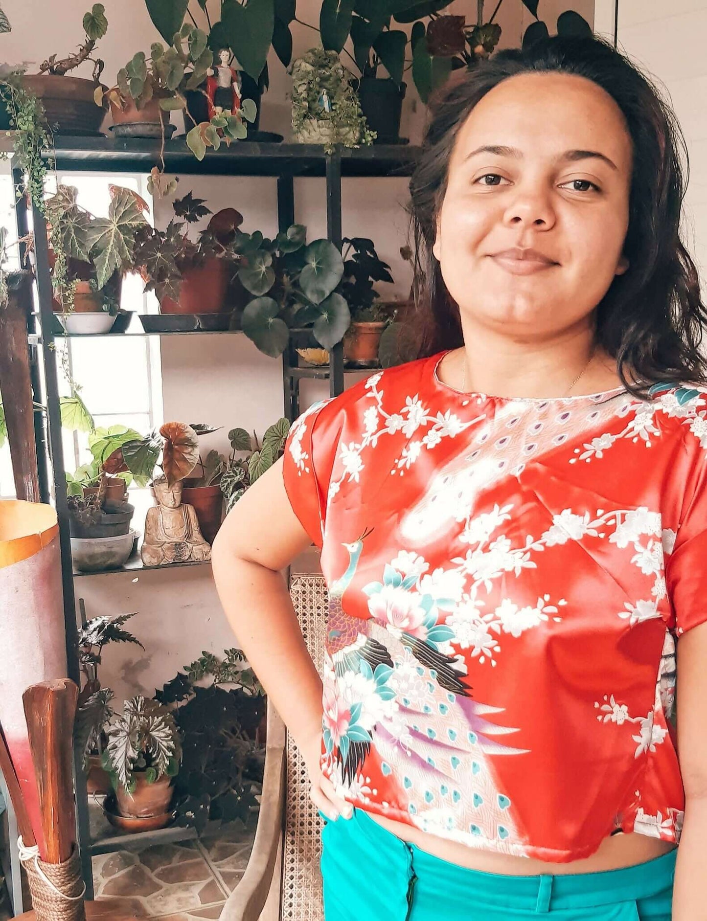 Femme portant un Top Antéros - T36 à 50, dos nu avec manches à revers, devant un étagère de plantes, patron de couture pdf à télécharger.