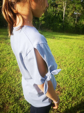 Fille portant un top à manches courtes avec nœuds, idéal pour la couture et exprimant des styles variés.