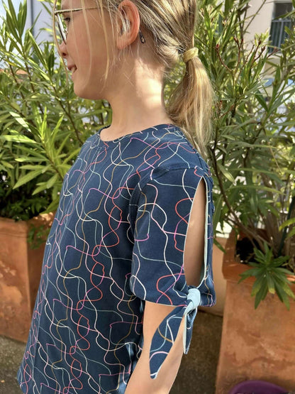 Top Chouchou pattern featuring a girl in a stylish, colorful blouse with tied sleeves outdoors.