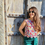 Femme portant le Top Fleury - T34 à 48, style estival coloré, patron de couture pdf à télécharger, sur fond de porte ancienne.