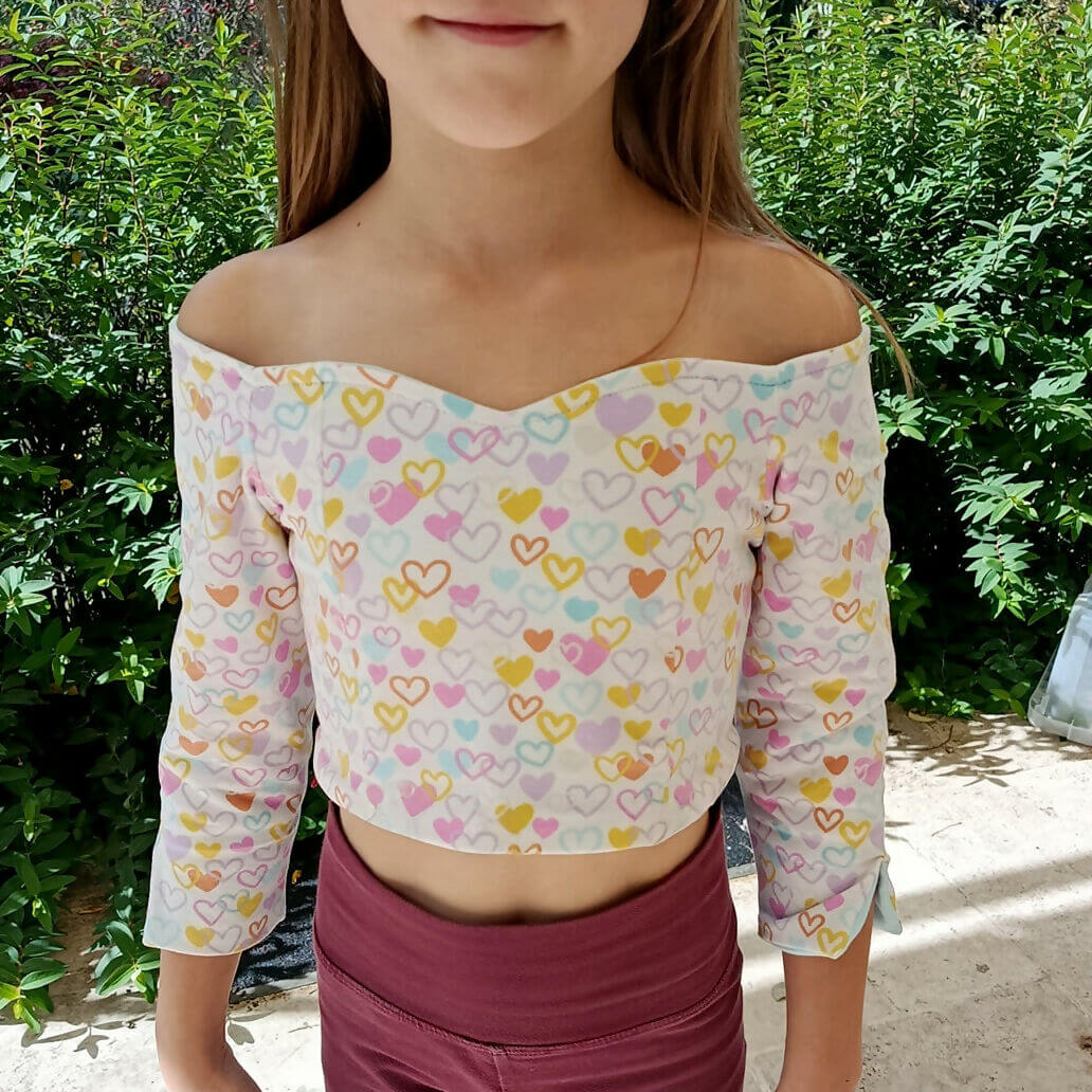 Fille portant le Top Yasmine Enfants, motif cœurs, patron de couture pdf à télécharger, manches 3/4, idéal pour personnaliser.