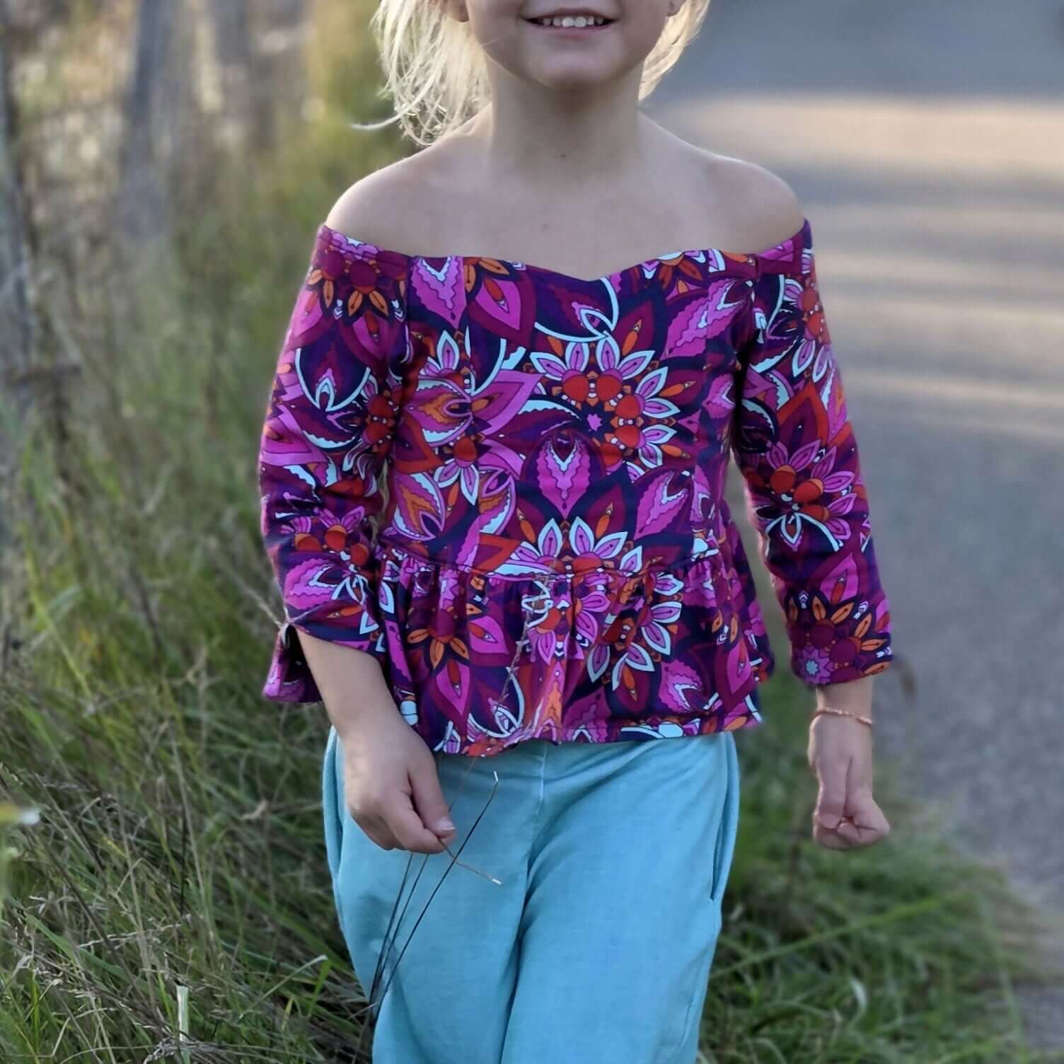 Jeune fille portant le Top Yasmine Enfants avec manche 3/4 à fente, patron de couture pdf à télécharger.