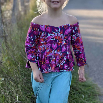 Jeune fille portant le Top Yasmine Enfants avec manche 3/4 à fente, patron de couture pdf à télécharger.