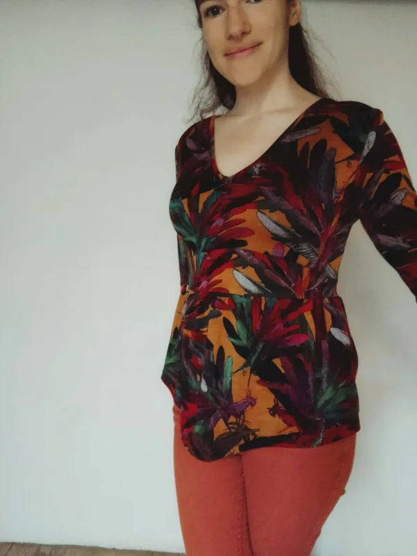 Femme portant un Top/Robe "Leonfe" du 32 au 56, avec encolure en V et motif coloré. Patron de couture PDF à télécharger disponible.