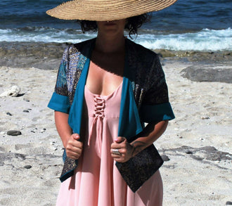 Femme portant la Veste Cybèle - T36 à 50 sur une plage, illustrant le patron de couture pdf à télécharger.