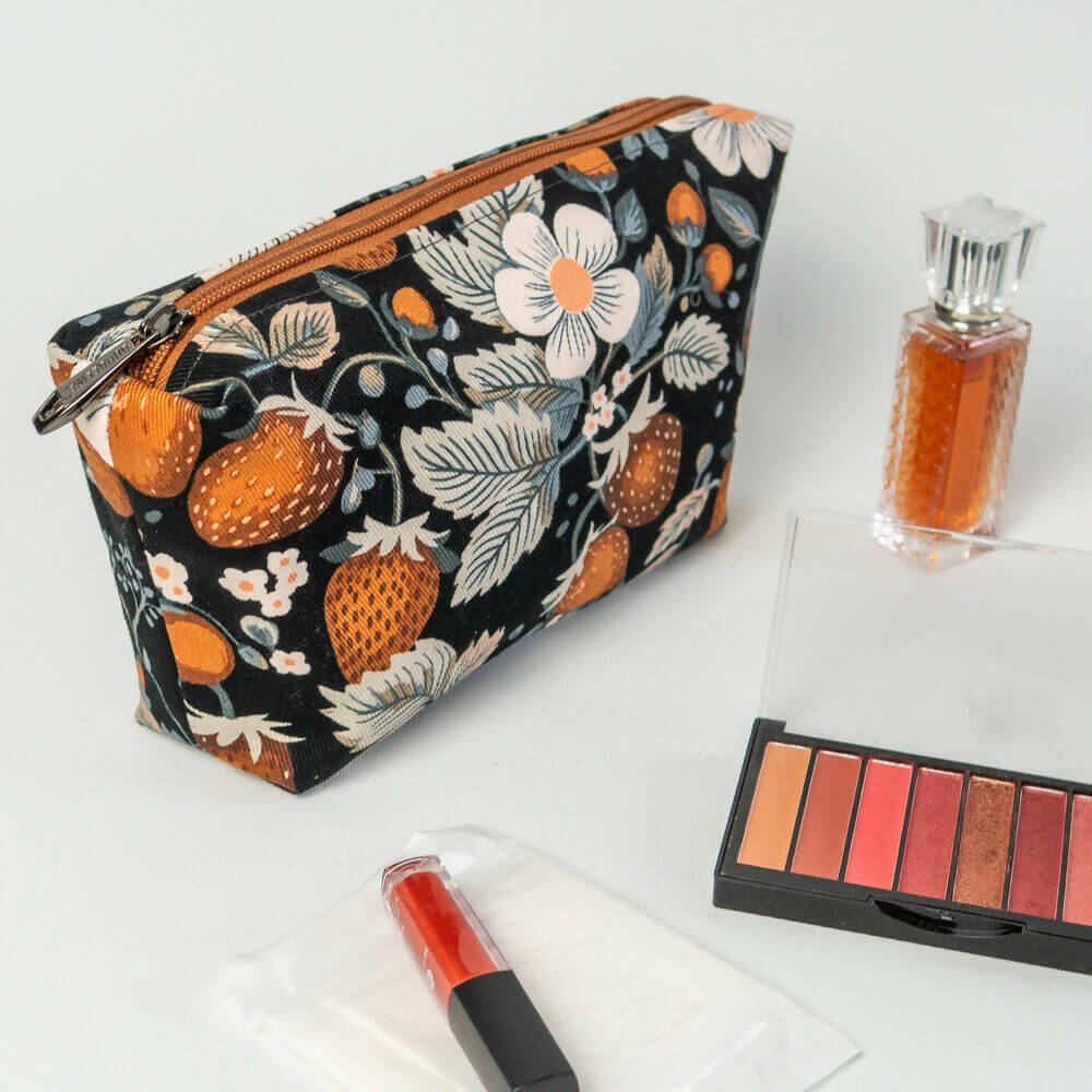 Trousse fourre-tout Fraise des bois avec maquillage, parfum et accessoires, pratique pour le voyage.