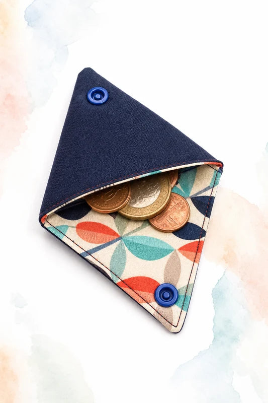 Porte-monnaie origami textile avec rabats triangulaires, boutons pression bleus et pièces, patron PDF gratuit.