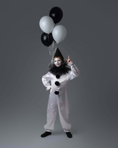 Enfant déguisé en clown ANALYA avec ballons noirs et blancs, prêt à s'amuser pour une fête.