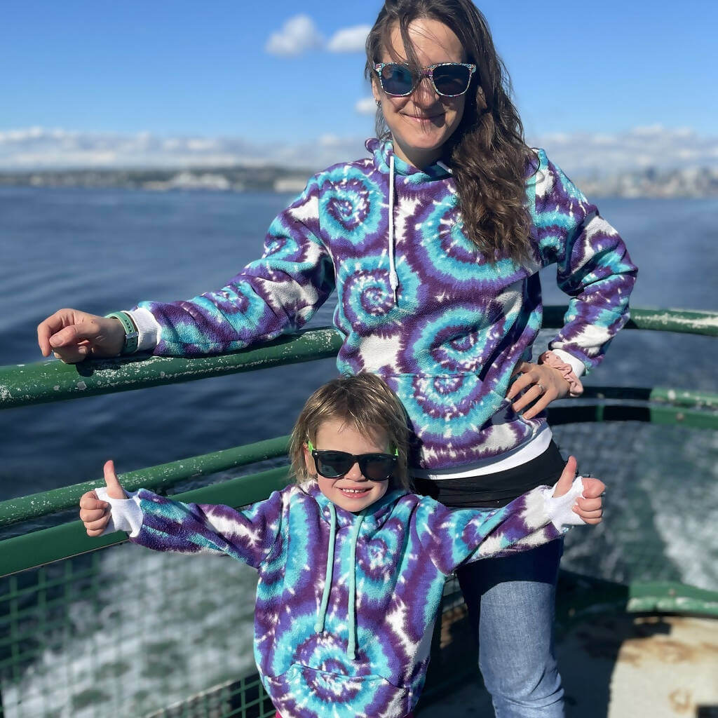 Duo sweat TITUS pour adultes (XS - XXXL) et enfants (2 - 16 Ans) en mer, portant des sweats assortis avec motif spirale colorée.