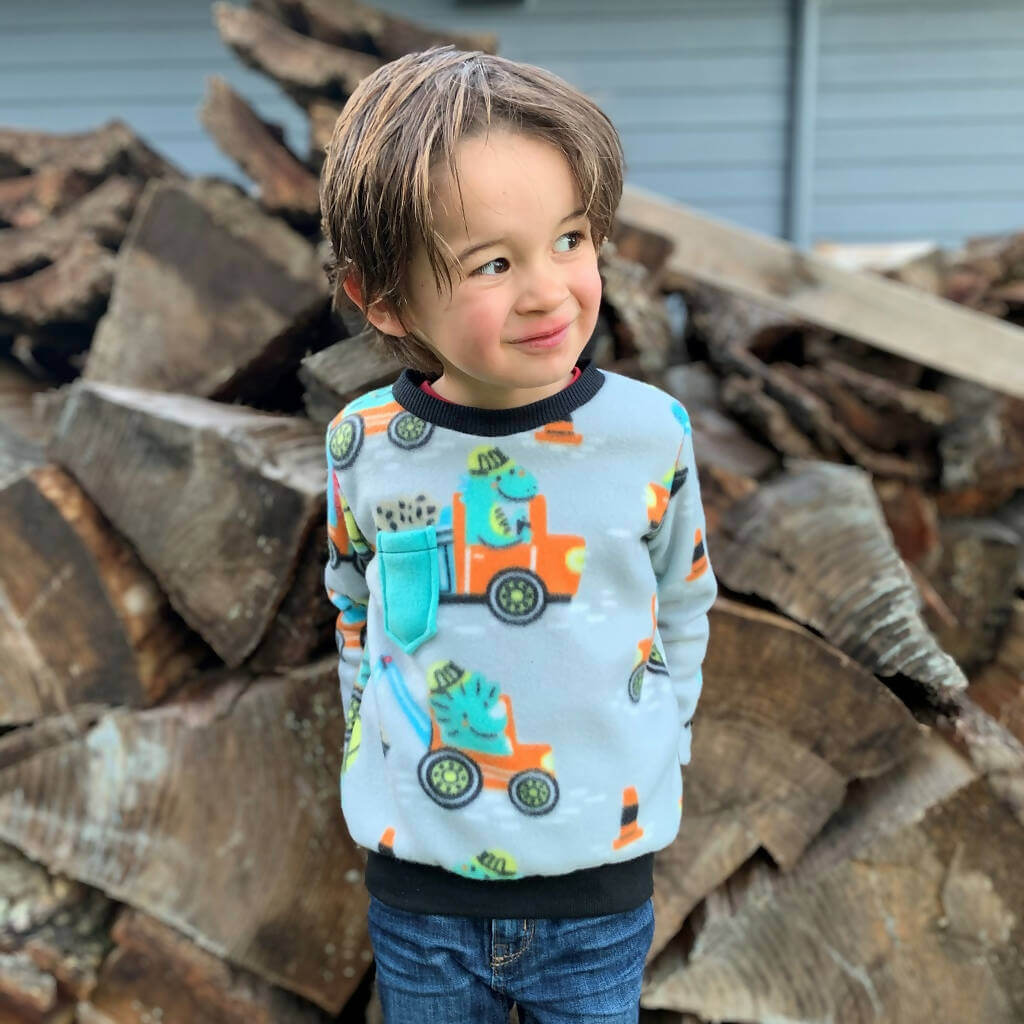 Enfant portant un sweat coloré devant un tas de bois, patron de couture pdf à télécharger Duo sweat TITUS pour adultes (XS - XXXL) et enfants (2 - 16 Ans).