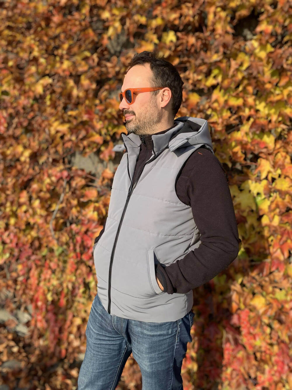 Homme portant la KEZIA - Doudoune sans manches mixte pour adultes du XS au XXXL, devant des feuilles d'automne, patron de couture pdf à télécharger.