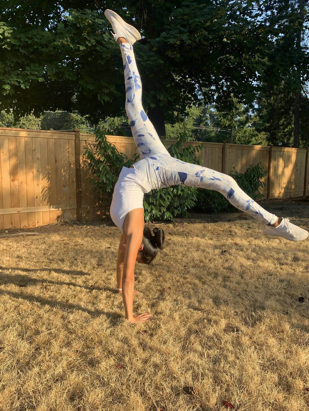 Femme en pleine séance de yoga portant le KIM - legging pour femmes du 34 au 54, patron de couture pdf à télécharger, dans un jardin.