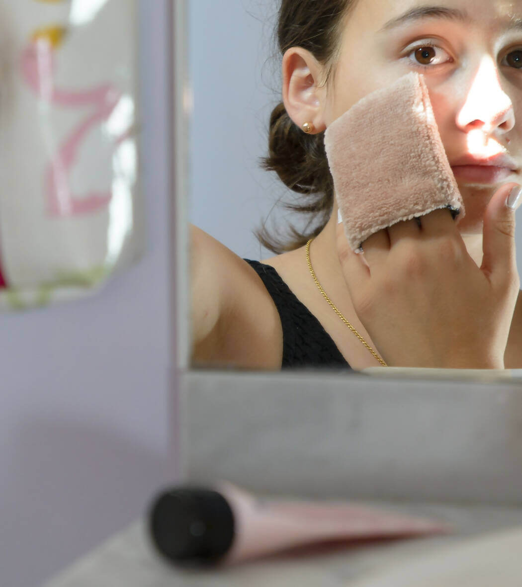 Femme utilisant une lingette gant biface lavable, zéro déchet – Cetera pour se démaquiller, avec patron de couture pdf à télécharger.