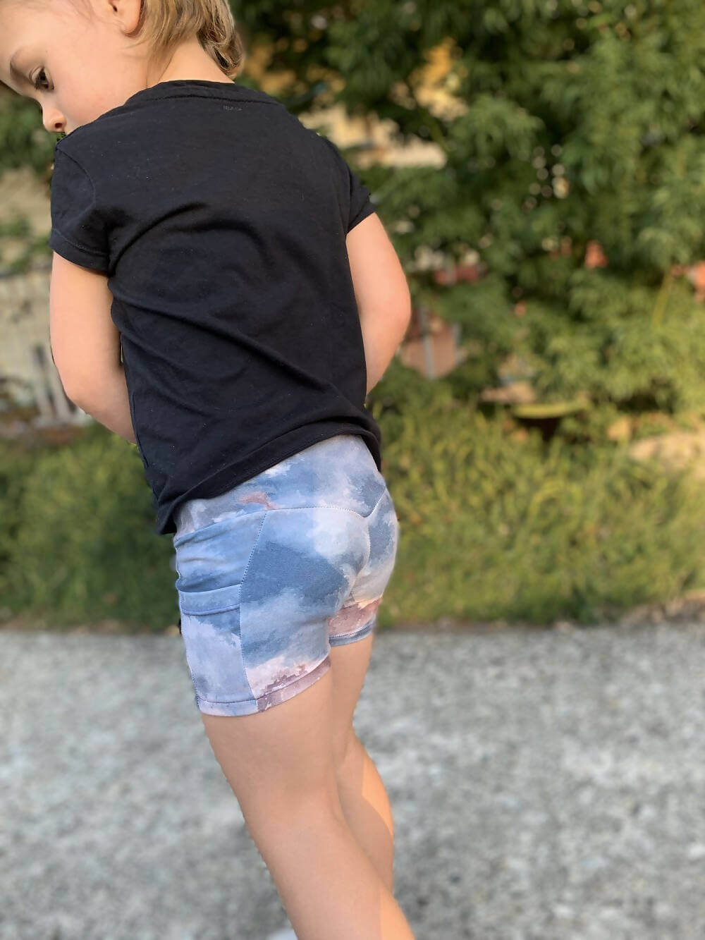 Mini-KIM - Legging pour filles du 2 au 16 Ans, patron de couture pdf à télécharger, enfant portant un short ciel dans un jardin