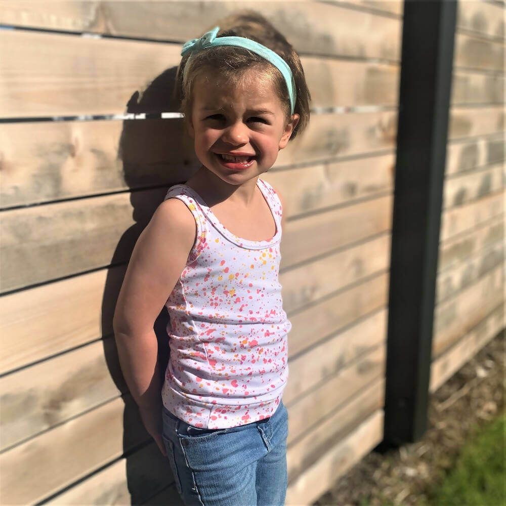 Fille portant le Mini-ROXANA - Débardeur en rose, patron de couture pdf à télécharger, tailles 2 à 16 ans, en extérieur.