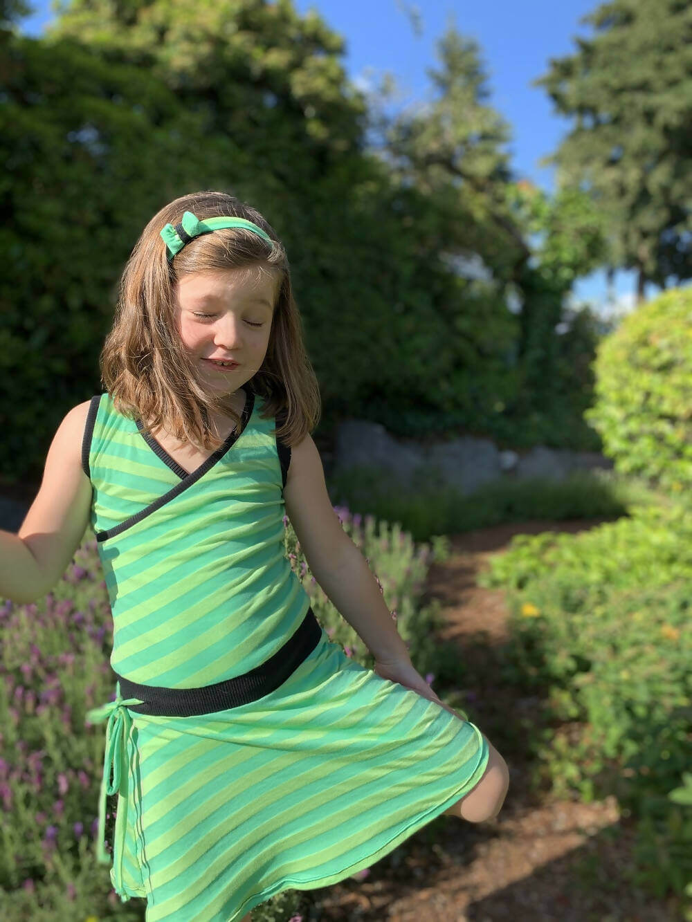 Mini-SANDY - Robe cache-coeur pour filles du 2 au 16 Ans, patron de couture pdf à télécharger, fille portant une robe verte dans un jardin